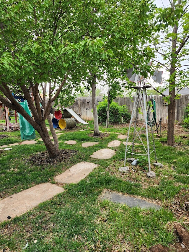 view of yard with fence and a playground