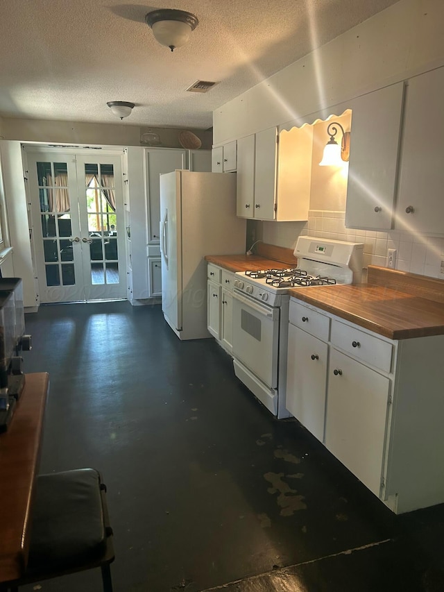 kitchen featuring french doors, white appliances, butcher block counters, and visible vents