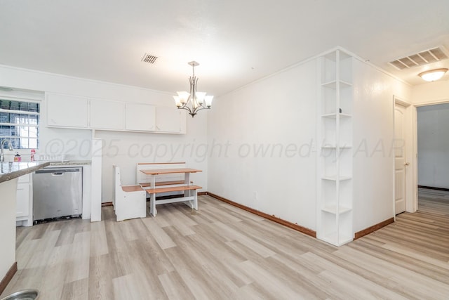2738 Palm St, Amarillo, TX 79107 - kitchen with stainless steel dishwasher, light wood-type flooring, white cabinetry, and light countertops