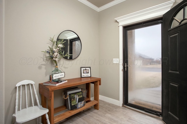 foyer entrance with ornamental molding and light hardwood / wood-style floors