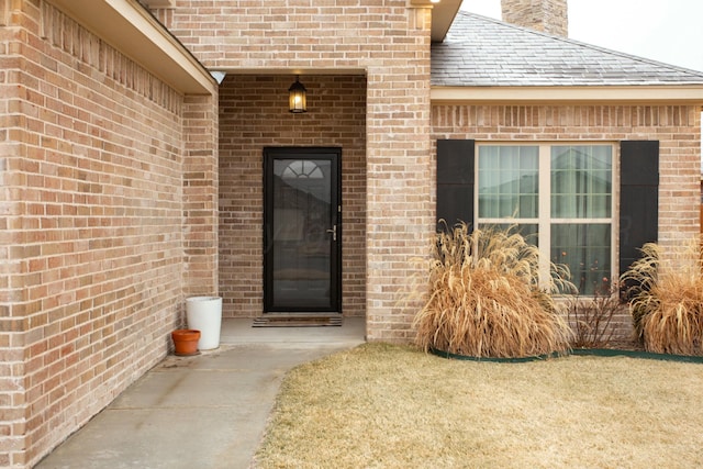 doorway to property featuring a lawn