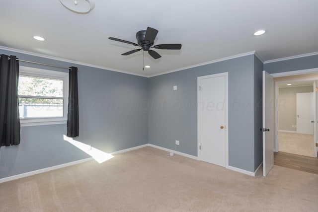 empty room featuring ceiling fan, light carpet, and ornamental molding