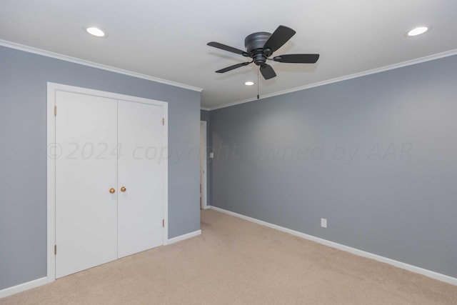 unfurnished bedroom featuring light colored carpet, ceiling fan, crown molding, and a closet