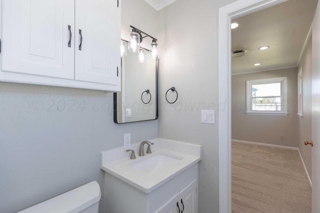 bathroom featuring toilet, vanity, and crown molding