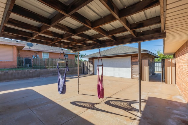 view of patio featuring a garage and an outbuilding