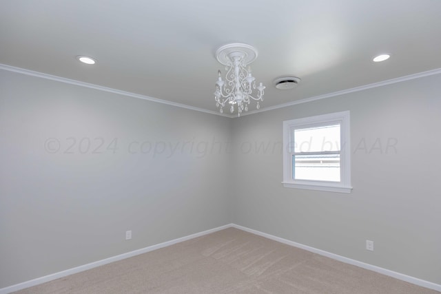 spare room with carpet flooring, a notable chandelier, and ornamental molding