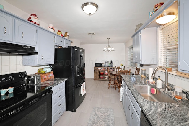 2904 Pittsburg St, Amarillo, TX 79103 - kitchen featuring black appliances, under cabinet range hood, a chandelier, dark stone countertops, and hanging light fixtures