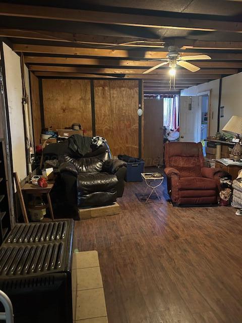 living room with hardwood / wood-style flooring, ceiling fan, and beam ceiling