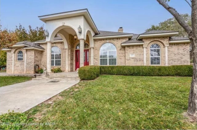 113 Port O Call Dr, Amarillo, TX 79118 - mediterranean / spanish house featuring brick siding, a chimney, and a front yard