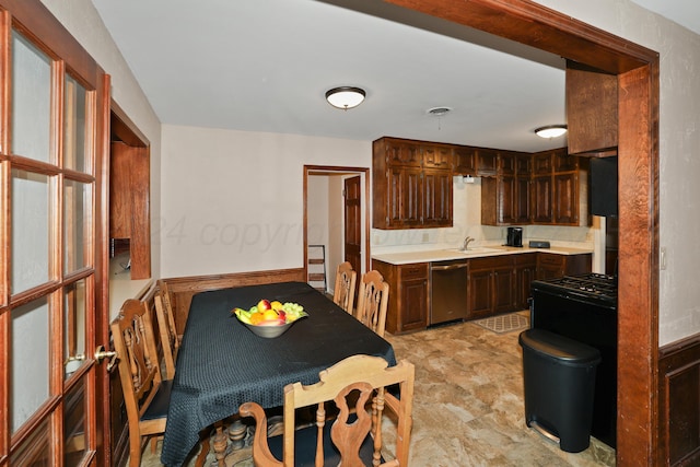kitchen with dishwasher, dark brown cabinetry, and sink