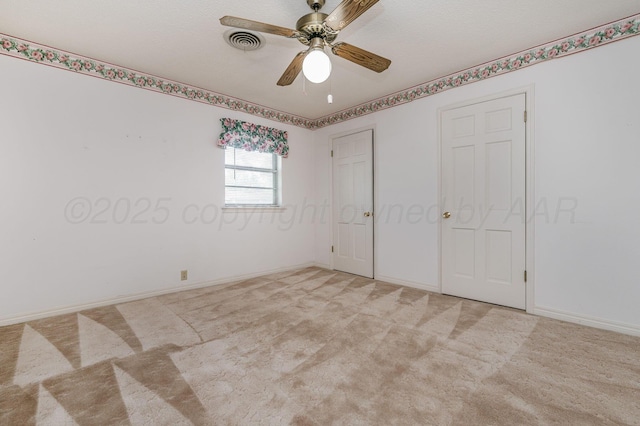 unfurnished bedroom with light colored carpet, a ceiling fan, and baseboards