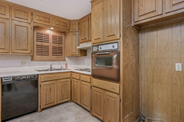 kitchen with black dishwasher, oven, a sink, light countertops, and light colored carpet