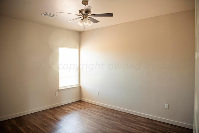 spare room featuring dark wood-type flooring and ceiling fan