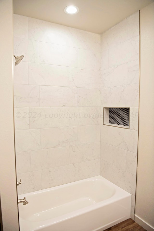 bathroom featuring tiled shower / bath combo and hardwood / wood-style flooring