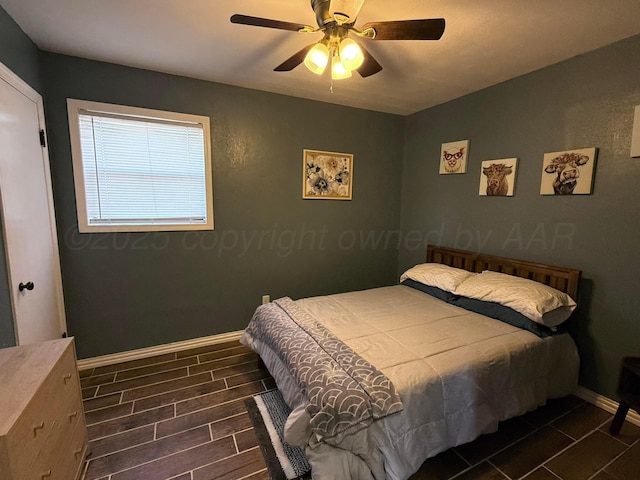 bedroom with baseboards, a ceiling fan, and wood tiled floor