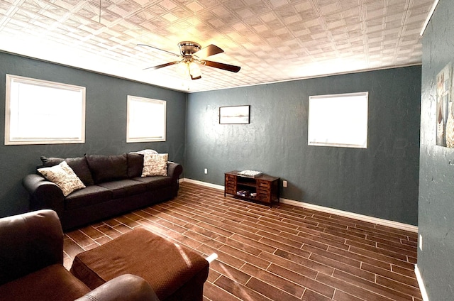 living room featuring an ornate ceiling, baseboards, ceiling fan, and wood finish floors