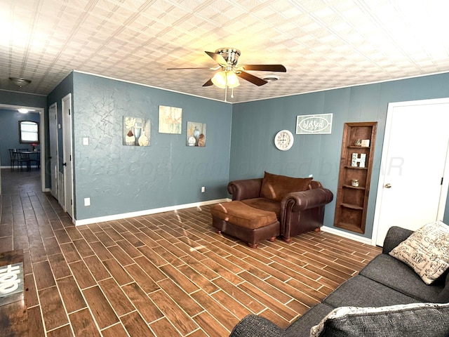 living area with a ceiling fan, a textured wall, dark wood finished floors, and baseboards