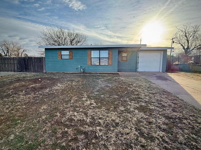 ranch-style house with an attached garage, fence, and concrete driveway