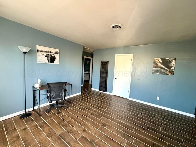 home office with wood tiled floor, visible vents, and baseboards