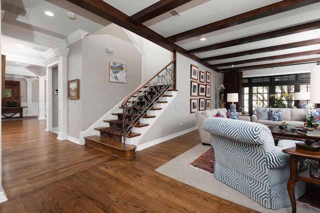 living room with hardwood / wood-style flooring, crown molding, ornate columns, and beamed ceiling