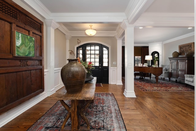 foyer featuring beamed ceiling, dark hardwood / wood-style flooring, ornate columns, and ornamental molding