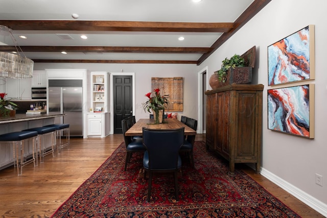 dining area with beam ceiling and dark hardwood / wood-style floors