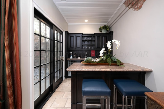 interior space with ornamental molding and a breakfast bar area