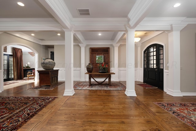 entryway with dark hardwood / wood-style floors, ornate columns, and ornamental molding