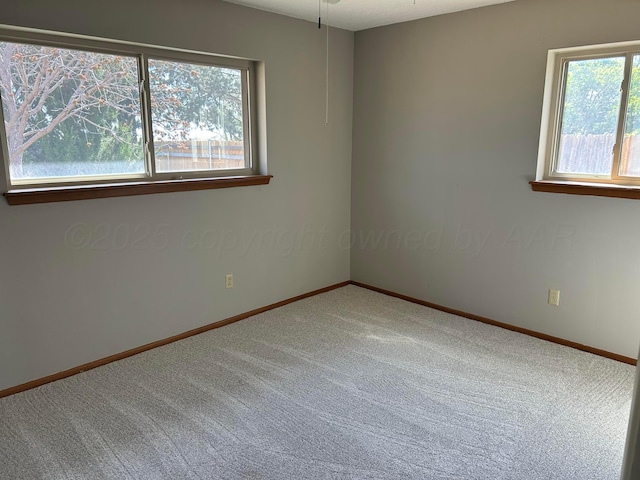 unfurnished room featuring carpet floors and baseboards