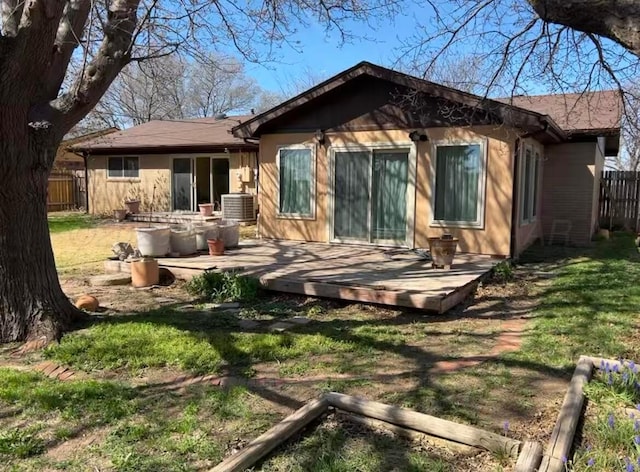 back of property with a yard, fence, a deck, and cooling unit