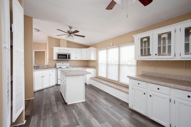 kitchen with stainless steel microwave, a ceiling fan, white electric stove, lofted ceiling, and a kitchen island