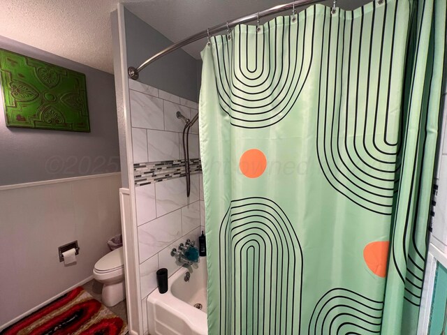 1400 16th St, Hereford, TX 79045 - bathroom featuring toilet, shower / bath combination with curtain, wainscoting, and a textured ceiling