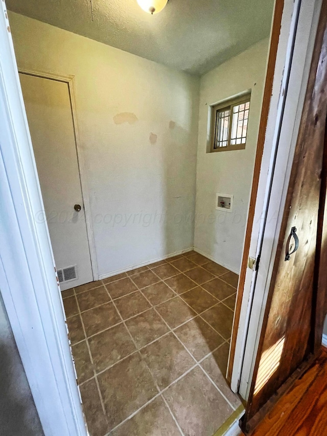 laundry area with hookup for a washing machine and dark tile patterned floors