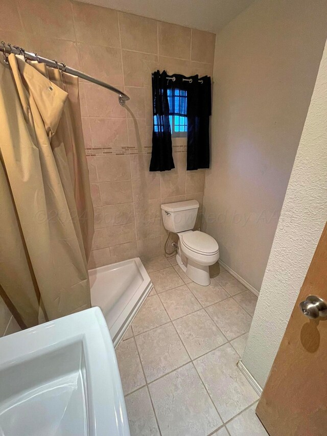 bathroom with toilet, tile patterned floors, and walk in shower