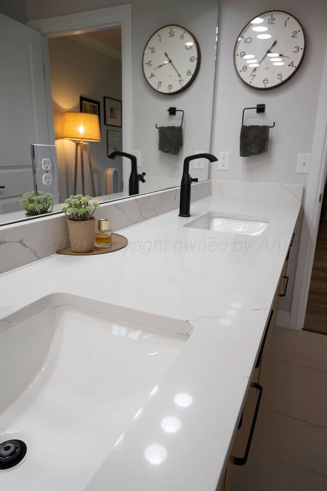 bathroom with double vanity and ornamental molding