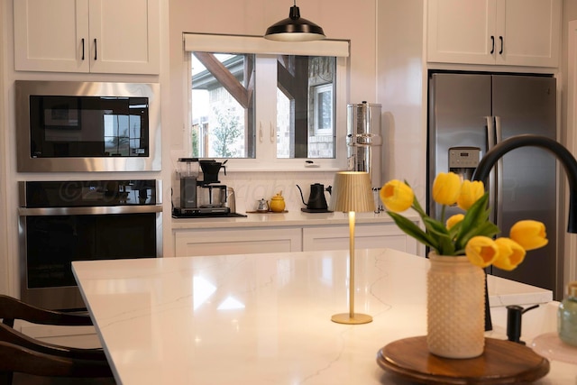 kitchen with appliances with stainless steel finishes, backsplash, and white cabinetry