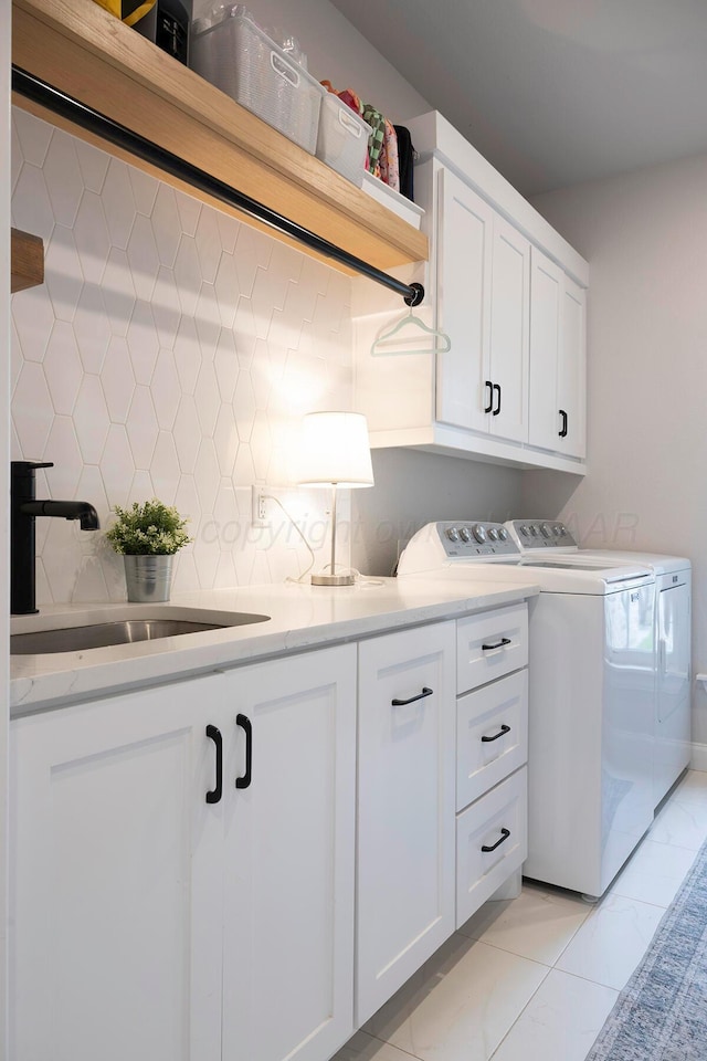 laundry room with washing machine and clothes dryer and cabinet space