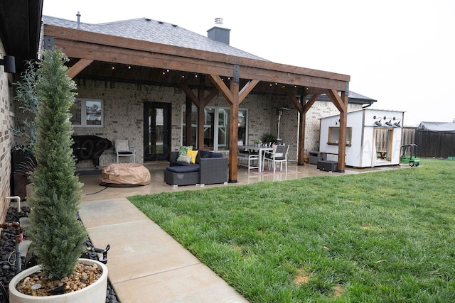 view of yard featuring a patio, an outdoor living space, an outbuilding, and a storage unit