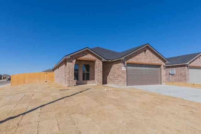 ranch-style home with brick siding, driveway, and an attached garage