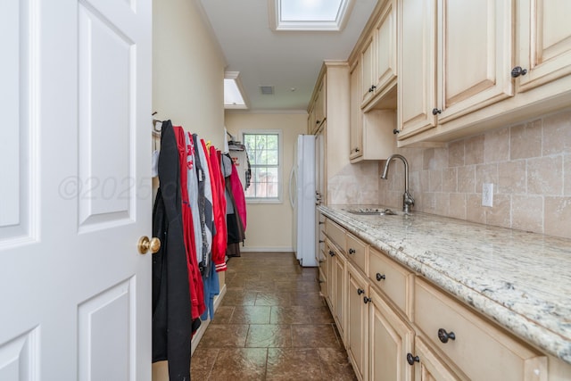 3501 Van Winkle Dr, Amarillo, TX 79121 - kitchen with a sink, cream cabinets, decorative backsplash, dark stone finish flooring, and baseboards
