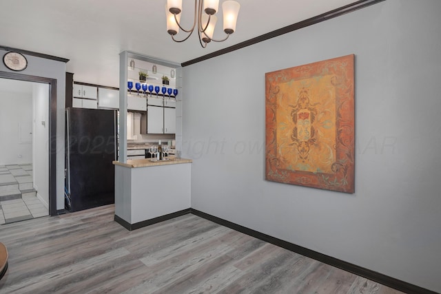 1805 Broadmoor St, Amarillo, TX 79106 - kitchen featuring freestanding refrigerator, crown molding, a chandelier, light wood-type flooring, and white cabinetry