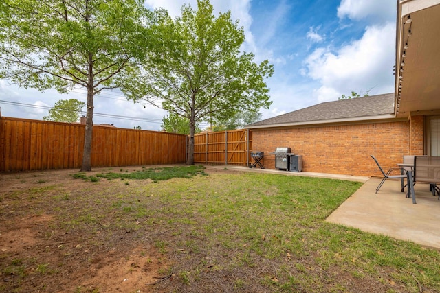 view of yard featuring a fenced backyard, a gate, and a patio area