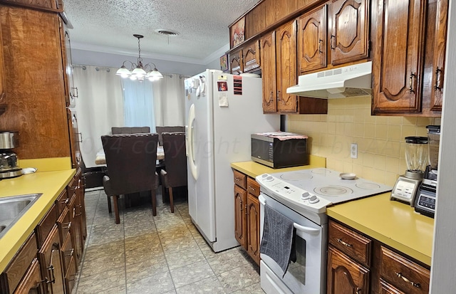 kitchen with hanging light fixtures, a textured ceiling, tasteful backsplash, a chandelier, and white appliances