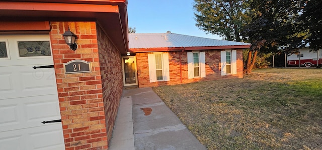 view of side of home featuring a garage and a lawn