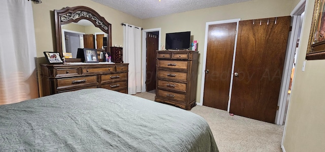 bedroom with a closet, a textured ceiling, and light carpet