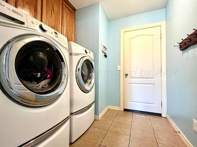 8400 El Paso Dr, Amarillo, TX 79118 - laundry room featuring light tile patterned flooring, baseboards, cabinet space, and washing machine and dryer