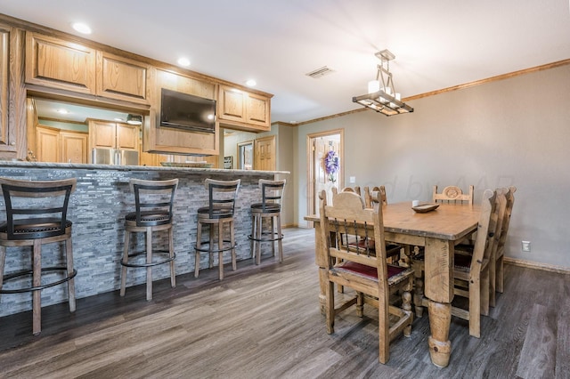 dining area featuring dark hardwood / wood-style flooring and ornamental molding