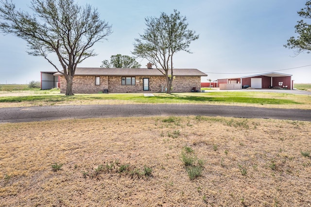 view of front of property featuring a garage, an outdoor structure, and a front yard