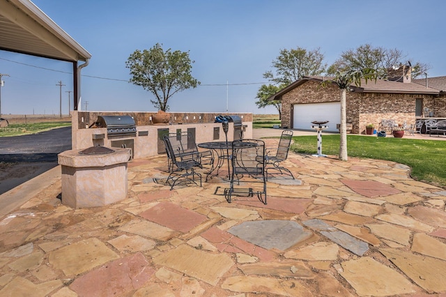 view of patio / terrace with a garage, exterior kitchen, and a grill