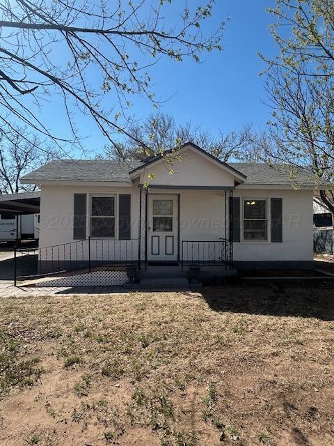 view of front of property featuring covered porch, roof with shingles, and a carport